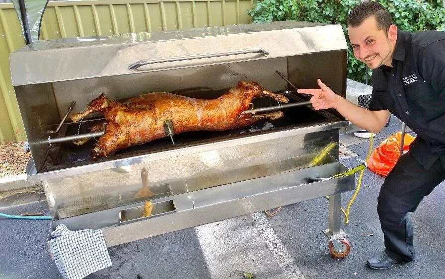 Ivan Tomic posing with a whole pig on the spit roast
